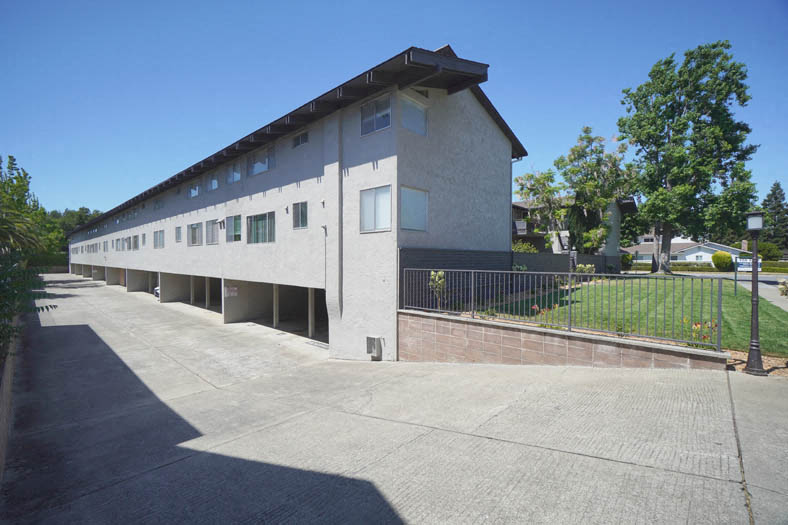 the side of a building with a street and a sidewalk